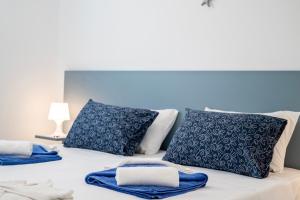 a bed with blue and white pillows on it at XENOS VILLA 7 with a private pool near the sea in Tigaki +43 photos