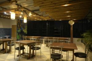古瓦哈提Hotel Pohor Regency Near Kamakhya Gate Foot Bridge的配有木桌椅的餐厅
