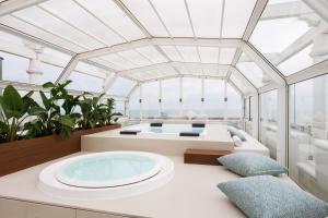a room with a hot tub on a yacht at Hotel De Londres in Rimini