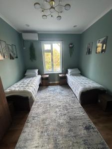 drei Betten in einem Zimmer mit Fenster in der Unterkunft Apartments with Registan view in Samarkand