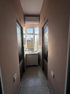 ein Badezimmer mit Waschbecken und Fenster in der Unterkunft Apartments with Registan view in Samarkand