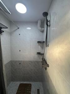 ein Bad mit einer Dusche, einem Waschbecken und einer Lampe in der Unterkunft Apartments with Registan view in Samarkand