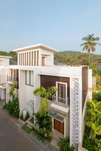 Una vista aérea de una casa blanca con palmeras. en Melhor Stays Villa - L-M309 Luxury 3BHK villa with Private pool at Anjuna, en Arpora