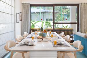 Un comedor con una mesa y sillas blancas. en Melhor Stays Villa - L-M309 Luxury 3BHK villa with Private pool at Anjuna, en Arpora