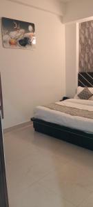 una camera da letto con due letti e un quadro sul muro di Hotel Blue Heaven Oyotownhouse a Ghaziabad Altre 8 foto