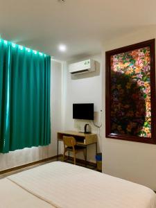 ein Zimmer mit einem Bett und einem Schreibtisch und einem Fenster in der Unterkunft Cloud7 hotel in Phu Quoc