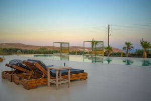 a pool with chairs and a table on top at Melisses in Mikonos