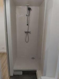 a shower stall in a white wall with a shower at Appartement Savigny - proche Orly in Savigny-sur-Orge
