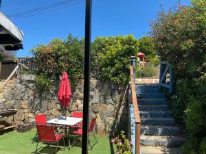 a patio with a table and chairs and a stone staircase at casa Marcela papudo in Papudo