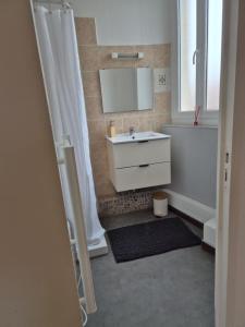 a bathroom with a white sink and a mirror at Le Sixty in Saint-Gaudens