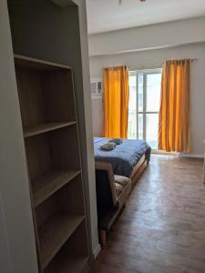 a bedroom with a bed and a window with orange curtains at Near Airport Luxury on a Budget Gym, Pool, 55 Smart TV, Balcony facing amenities in Pusok +8 photos