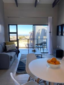 a living room with a white table and a couch at Lagoon Views Luxury Apartment Langebaan in Langebaan