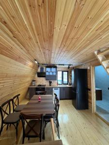 a kitchen and dining room with a wooden ceiling at Cozy Cottage JuFu in Mestia