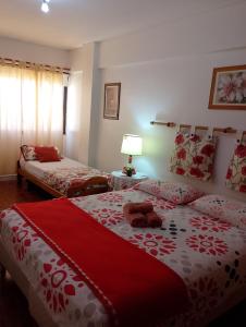 1 Schlafzimmer mit 2 Betten und einer roten und weißen Decke in der Unterkunft 4 Aparts en el mismo edificio, excelente ubicación in Buenos Aires