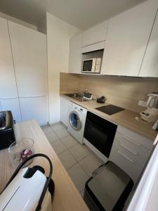 a kitchen with a washing machine and a microwave at Studio Residence Du Casino in Menton