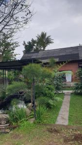 ein Haus mit einem Garten davor in der Unterkunft Datu Villa Sembalun in Sembalun Lawang