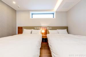 two beds in a small room with a window at Jeju Dalmaru in Jeju +21 photos