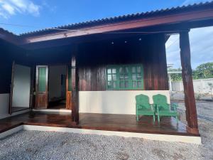 a house with two green chairs on a porch at Bann Aui Homestay in Fang