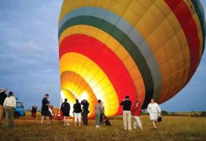 a group of people standing in a field with a large balloon at Mara Green Heart in Sekenani