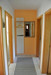 einen Flur mit Tür und Spiegel in einem Zimmer in der Unterkunft "Am Prerow Strom" in Prerow