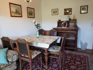 a dining room with a table and a piano at "Am Prerow Strom" in Prerow