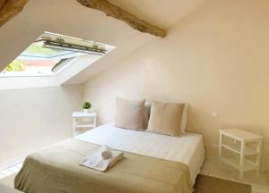 a bedroom with a bed in a room with a window at Le Cottage Brantôme in Bourrou