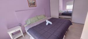 a bedroom with a purple bed with a stuffed animal on it at alojateenazul2024 in Azul