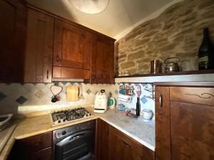 a kitchen with wooden cabinets and a stove top oven at Ca'de Picchio in Arezzo