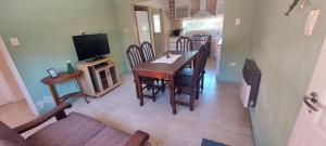 a dining room with a table and chairs and a television at alojateenazul2024 in Azul