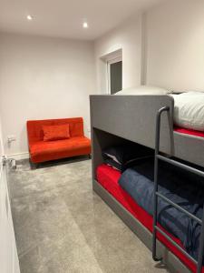 a bedroom with a bunk bed and an orange chair at Luxury Spacious Flat close to Central London in London