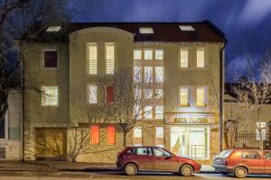 two cars parked in a parking lot in front of a building at Kata Panzió in Szeged