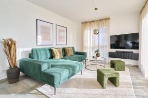 a living room with a green couch and stool at Bernstein Apartments in Pouch