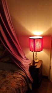 Eine Lampe steht auf einem Nachttisch neben einem Bett. in der Unterkunft Magisches Schlafzimmer in Hamburg