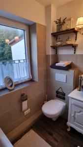 ein Bad mit einem WC, einem Fenster und einem Waschbecken in der Unterkunft Magisches Schlafzimmer in Hamburg