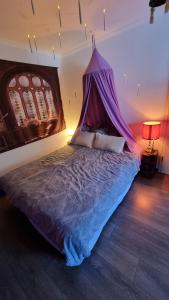 ein Bett mit einem lila Baldachin in einem Zimmer in der Unterkunft Magisches Schlafzimmer in Hamburg