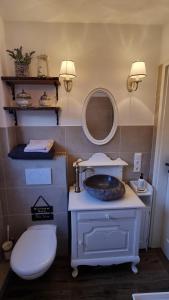 ein Badezimmer mit Waschbecken, Toilette und Spiegel in der Unterkunft Magisches Schlafzimmer in Hamburg