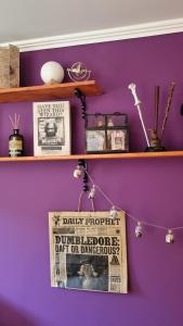 eine lila Wand mit Regalen und einem Schild daran in der Unterkunft Magisches Schlafzimmer in Hamburg + 3 Fotos