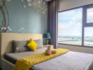 a bedroom with a bed with a yellow blanket at Vinhomes Ocean Park Gia Lam by QMP in Hanoi