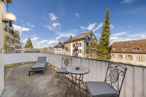 een terras met twee stoelen en een tafel op een balkon bij Aparthotel Mama Home Stankt Georgen in St. Gallen