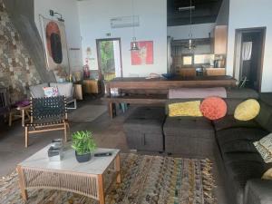 a living room with a couch and a piano at Sunrise House Azores - jacuzzi in Senhora da Nazaré