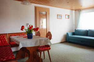 a living room with a table and a blue couch at Ferienwohnung Czornebohblick in Kubschütz +18 photos
