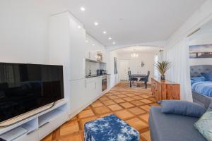 een woonkamer met een grote flatscreen-tv bij Aparthotel Mama Home Stankt Georgen in St. Gallen