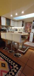 a kitchen with white bar stools on a tile floor at Gelsomino a San Pietro in Rome