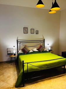 a bedroom with a green bed with two lamps at Sicilia Vacation rooms in Trapani +26 photos