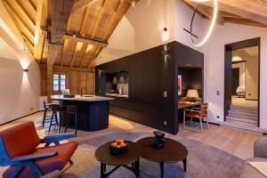 an open kitchen and living room with wooden ceilings at Les Suites by Cave Vauban in Dijon