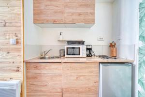 une cuisine avec un micro-ondes et un évier dans l'établissement Studio Himalaya-Au coeur de la ville, à Palaiseau 6 autres photos