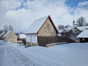 a house in the snow with a snowy road at Dubáčik Dovalovo in Liptovský Hrádok