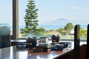 a table with food on it with a view of the ocean at Koran no Yu Kinkouro in Ibusuki