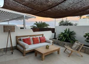 a patio with a couch and a table and a chair at Beach Front House 'Casa Neen' in Corralejo