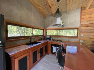 a kitchen with a wooden counter top and some windows at Refugio en Malalcahuello in Malalcahuello